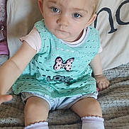 Keisha is registered to the contest to win money with this photo: toddler, child, baby, sitting, reaching, blue_eyes, mint_green_dress, butterfly, love_text, socks, cartoon_socks, blanket, indoor, cute, portrait, curious, young_child, light_hair, cozy, soft_texture