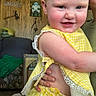 Avery is registered to the contest to win money with this photo: baby, child, smiling, yellow_clothing, gingham, red_hair, blue_eyes, indoor, wood_paneling, adult_hand, holding, cute, face, person, portrait, home, furniture, decor, happy, infant