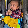 baby, child, plaid_shirt, denim_overalls, car_seat, gray, yellow_plush_toy, teether, toy, infant, cute, hands, chewing, clothing, seatbelt, indoor, portrait, young_child, person, casual