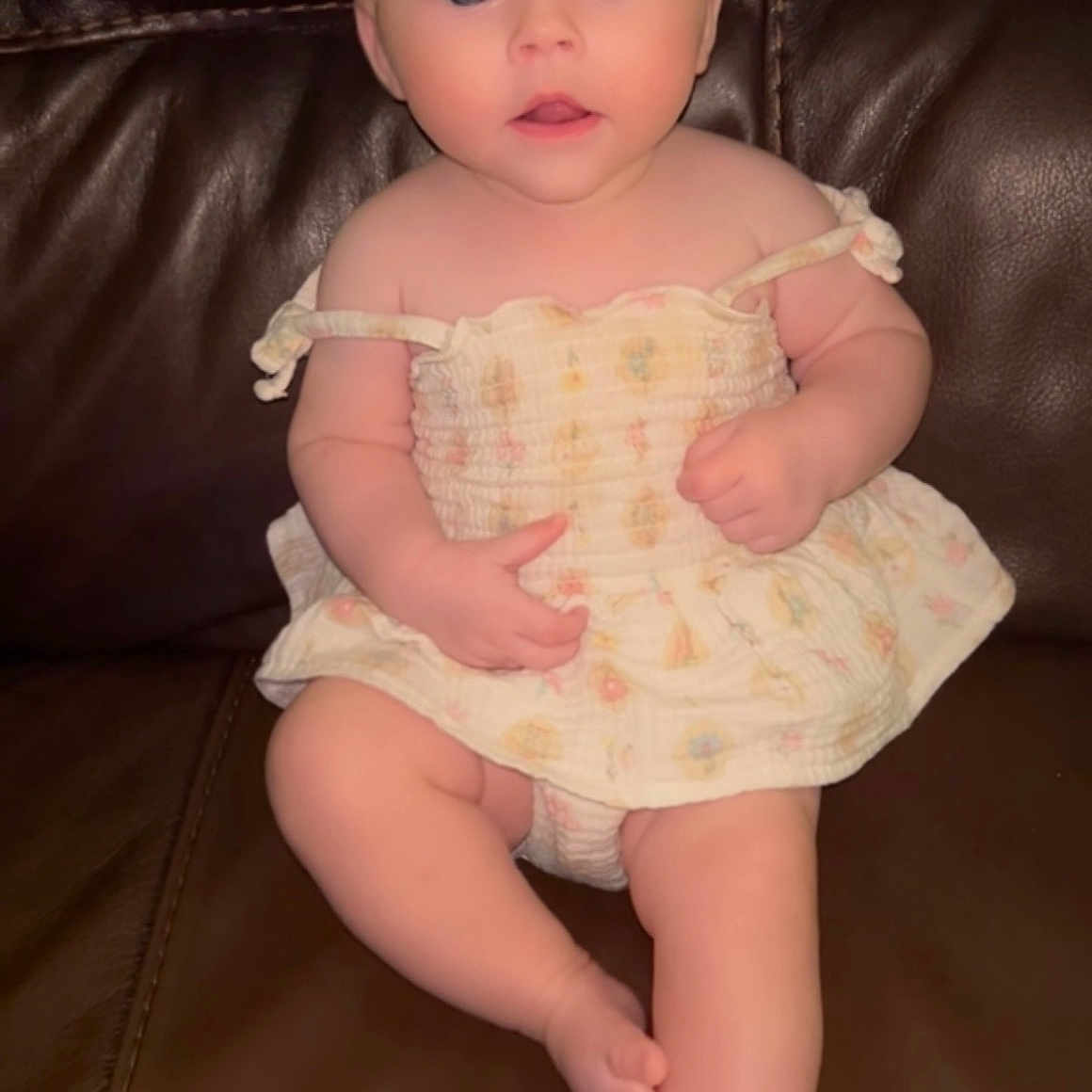Sadie joined the competition — help win amazing prizes! arms, baby, bare_shoulders, blue_eyes, child, couch, cute, dress, expression, face, furniture, indoors, infant, leather, legs, person, portrait, sitting, skin, young