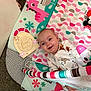 baby, infant, smiling, play_mat, toy, colorful, pink, teal, floral_pattern, clothing, cute, child, happy, lying_down, indoor, soft_texture, four_months, playtime, person, face