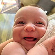 Rory is registered to the contest to win money with this photo: baby, smiling, close_up, face, infant, skin, arm, happy, indoors, couch, blanket, head, expression, cheerful, newborn, portrait, cute, child, person, soft