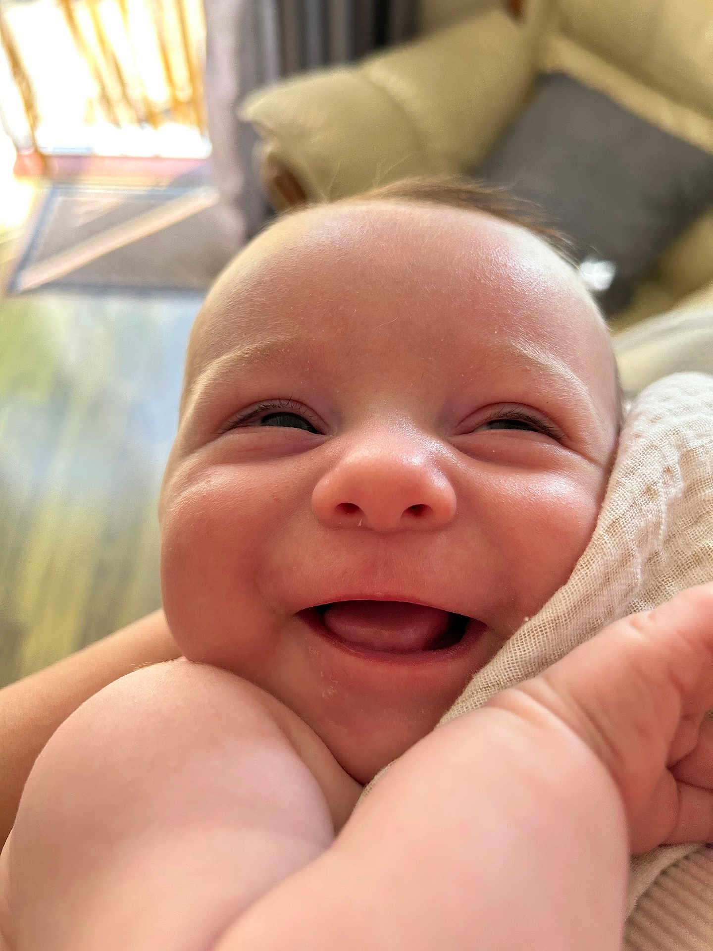 Rory is registered to the contest to win money with this photo: baby, smiling, close_up, face, infant, skin, arm, happy, indoors, couch, blanket, head, expression, cheerful, newborn, portrait, cute, child, person, soft