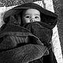 baby, child, face, hooded_towel, wrapped, blanket, cozy, soft, star_pattern, mat, indoors, cute, expression, wide_eyes, infant, towel, comfort, rest, portrait, black_and_white