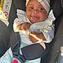 baby, child, car_seat, smiling, headband, white_clothing, infant, happy, portrait, seatbelt, close_up, safety, cute, indoors, person, young_child, toddler, clothing, funny_face, sunlight