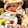 baby, child, infant, car_seat, blanket, hoodie, hat, cute, warm_clothing, bundle, face, eyes, hand, seatbelt, indoor, soft_texture, clothing, portrait, snuggle, cozy