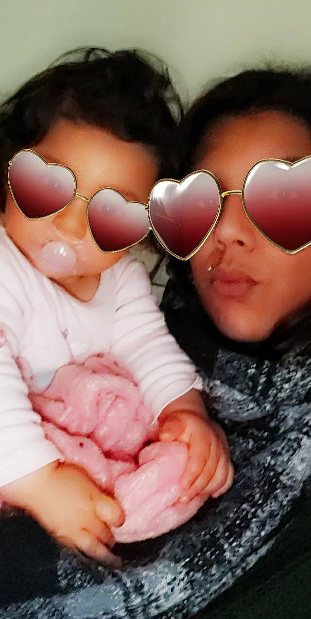 Shérine participe au concours pour gagner de l'argent avec cette photo : baby, baby_toddler_clothing, cheek, chin, eye, eyewear, face, finger, gesture, goggles, happy, head, lip, mouth, nose, person, pink, skin, sunglasses, toddler