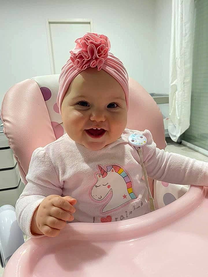 Keyna a rejoint le concours — aidez-le/la à gagner de superbes lots ! arm, baby, baby_laughing, baby_products, baby_toddler_clothing, cap, chair, cheek, child, curtain, fashion_accessory, fun, happy, headband, headwear, person, pink, skin, sleeve, smile
