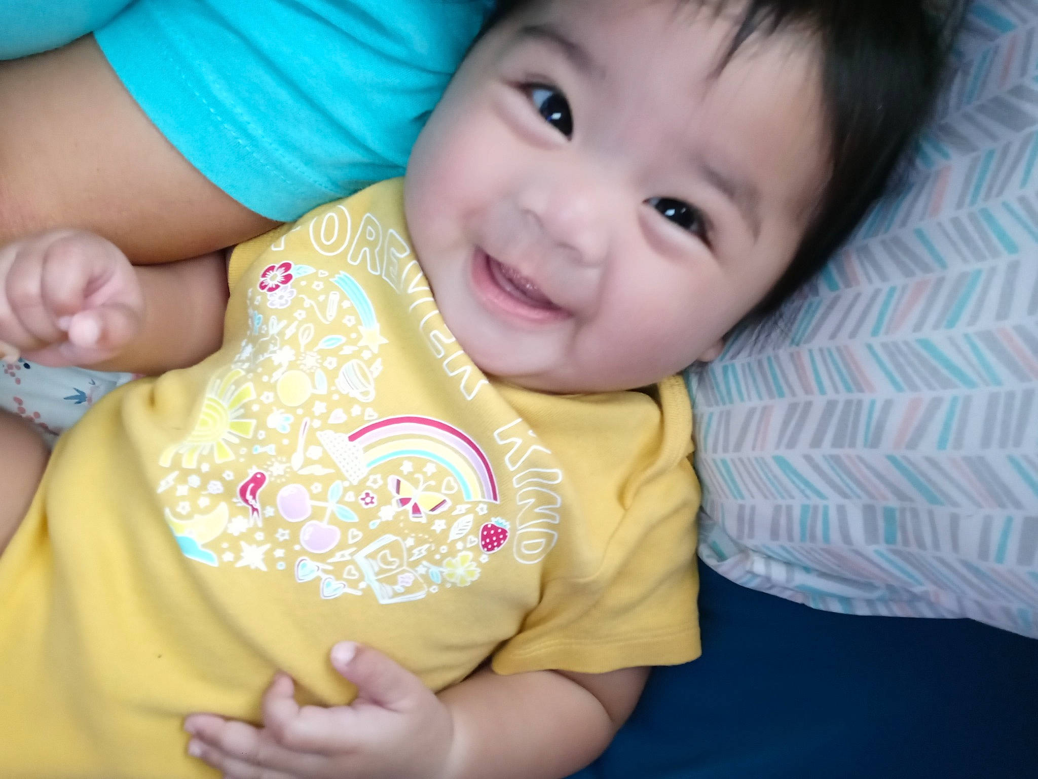 Camila is registered to the contest to win money with this photo: baby_toddler_clothing, blue, cheek, chin, comfort, dress, eye, face, finger, gesture, happy, human_body, iris, joy, lip, mouth, nose, person, skin, sleeve