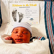 Antonio joined the competition — help win amazing prizes! newborn, baby, infant, sleeping, hospital, blanket, cap, birth_announcement, footprints, card, striped_blanket, closeup, portrait, resting, cute, child, person, indoors, hospital_bed, cozy