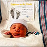 newborn, baby, infant, sleeping, hospital, blanket, cap, birth_announcement, footprints, card, striped_blanket, closeup, portrait, resting, cute, child, person, indoors, hospital_bed, cozy