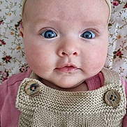 Elodie joined the competition — help win amazing prizes! baby, infant, face, blue_eyes, headband, bow, knitted_clothing, buttons, pink_clothing, floral_background, blanket, closeup, portrait, cute, child, young, skin, expression, person, indoors