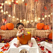 Castiel is registered to the contest to win money with this photo: autumn, baby, child, cute, decorations, fall_leaves, festive, holiday, indoors, infant, orange, portrait, pumpkin, seasonal, sitting, six_months, smiling, string_lights, toy, wooden_backdrop