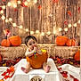 autumn, baby, child, cute, decorations, fall_leaves, festive, holiday, indoors, infant, orange, portrait, pumpkin, seasonal, sitting, six_months, smiling, string_lights, toy, wooden_backdrop