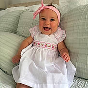 Sienna joined the competition — help win amazing prizes! baby, child, smiling, dress, headband, pink, white, couch, pillow, indoor, happy, cute, sitting, infant, portrait, person, clothing, headwear, soft, home