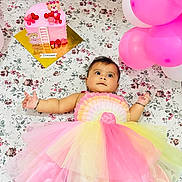 Jinie is registered to the contest to win money with this photo: baby, balloons, birthday, cake, celebration, child, colorful, cute, decorations, dress, festive, floral_blanket, happy, infant, lying_down, party, pink, portrait, toy_bear, yellow