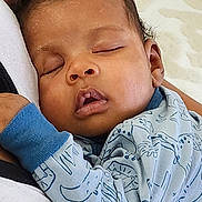 Azariah joined the competition — help win amazing prizes! baby, sleeping, infant, child, blue_clothing, animal_print, couch, cushion, peaceful, resting, indoor, closeup, portrait, young_child, relaxing, soft_texture, head, face, hand, cozy