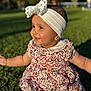 Rima joined the competition — help win amazing prizes! baby, child, girl, smiling, headband, bow, floral_dress, grass, outdoor, sunlight, park, happy, cute, portrait, nature, sitting, person, head, face, young_child