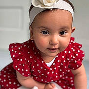 Rima is registered to the contest to win money with this photo: baby, child, girl, headband, flower, red_dress, polka_dot, crawling, indoor, portrait, cute, smiling, skin, face, eyes, hand, white_socks, soft_light, closeup, infant