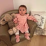 armchair, baby, child, cute, decor, floor, furniture, indoor, infant, nursery, person, pillow, pink_dress, plush_toy, sitting, sock, soft_toy, wall, white_legwear, wooden_floor