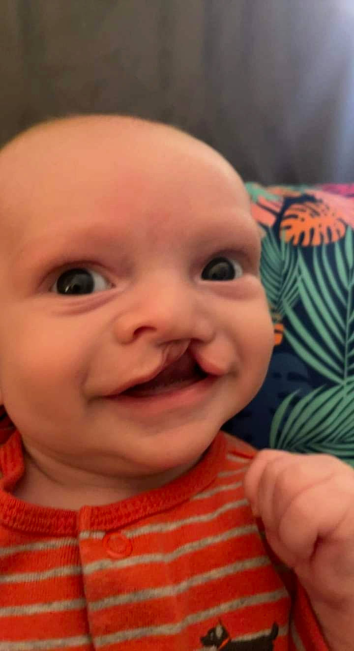 Andrew is registered to the contest to win money with this photo: baby, cheek, chin, eye, eyebrow, forehead, gesture, hand, happy, human_body, iris, lip, mouth, neck, nose, person, pink, skin, sleeve, smile