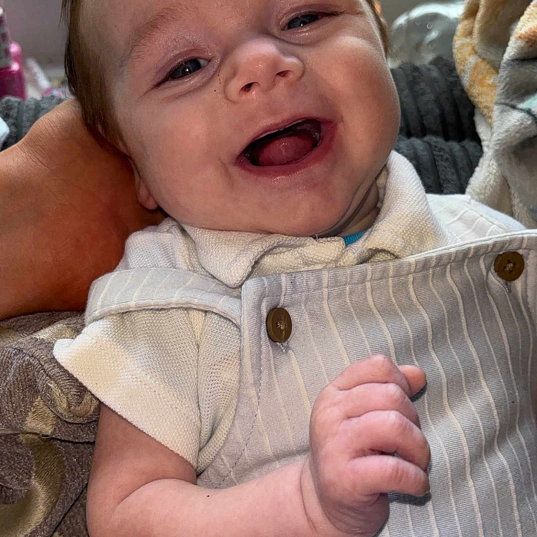 Harrison-James is registered to the contest to win money with this photo: baby, background, child, clothing, comfort, cozy, cute, expression, face, hand, happy, indoor, infant, person, portrait, skin, smiling, striped_outfit, window, young