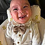baby, baby_seat, bow_tie, buttons, child, clothing, drool, eyes, face, happy, home, indoor, infant, mouth, onesie, pillow, portrait, smiling, teddy_bear_pattern, tongue