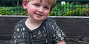 Levi joined the competition — help win amazing prizes! child, boy, smiling, sitting, bench, outdoor, garden, flowers, greenery, fence, casual_clothing, short_hair, daylight, portrait, happy, nature, wood, playful, park, cute