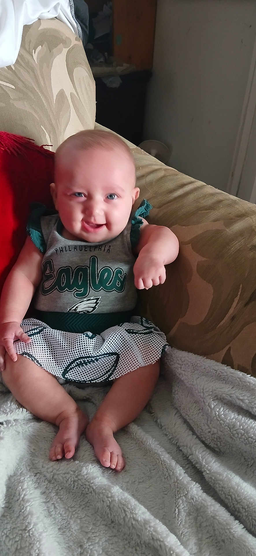Lydiarose is registered to the contest to win money with this photo: baby, smiling, sitting, couch, blanket, clothing, infant, happy, face, person, indoors, feet, apparel, sportswear, Philadelphia, Eagles, cute, child, portrait, home