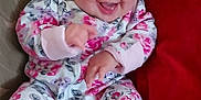 Lydiarose joined the competition — help win amazing prizes! baby, smiling, infant, floral_onesie, couch, red_pillow, happy, sitting, indoors, cute, child, patterned_fabric, joyful, face, person, home, cozy, small_hands, footed_pajamas, cheerful