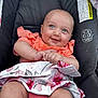 Lydiarose is registered to the contest to win money with this photo: baby, smiling, blue_eyes, infant, car_seat, coral_clothing, floral_skirt, cute, happy, child, seatbelt, safety_labels, indoors, person, portrait, young_child, small_hands, legs, casual_wear, comfortable