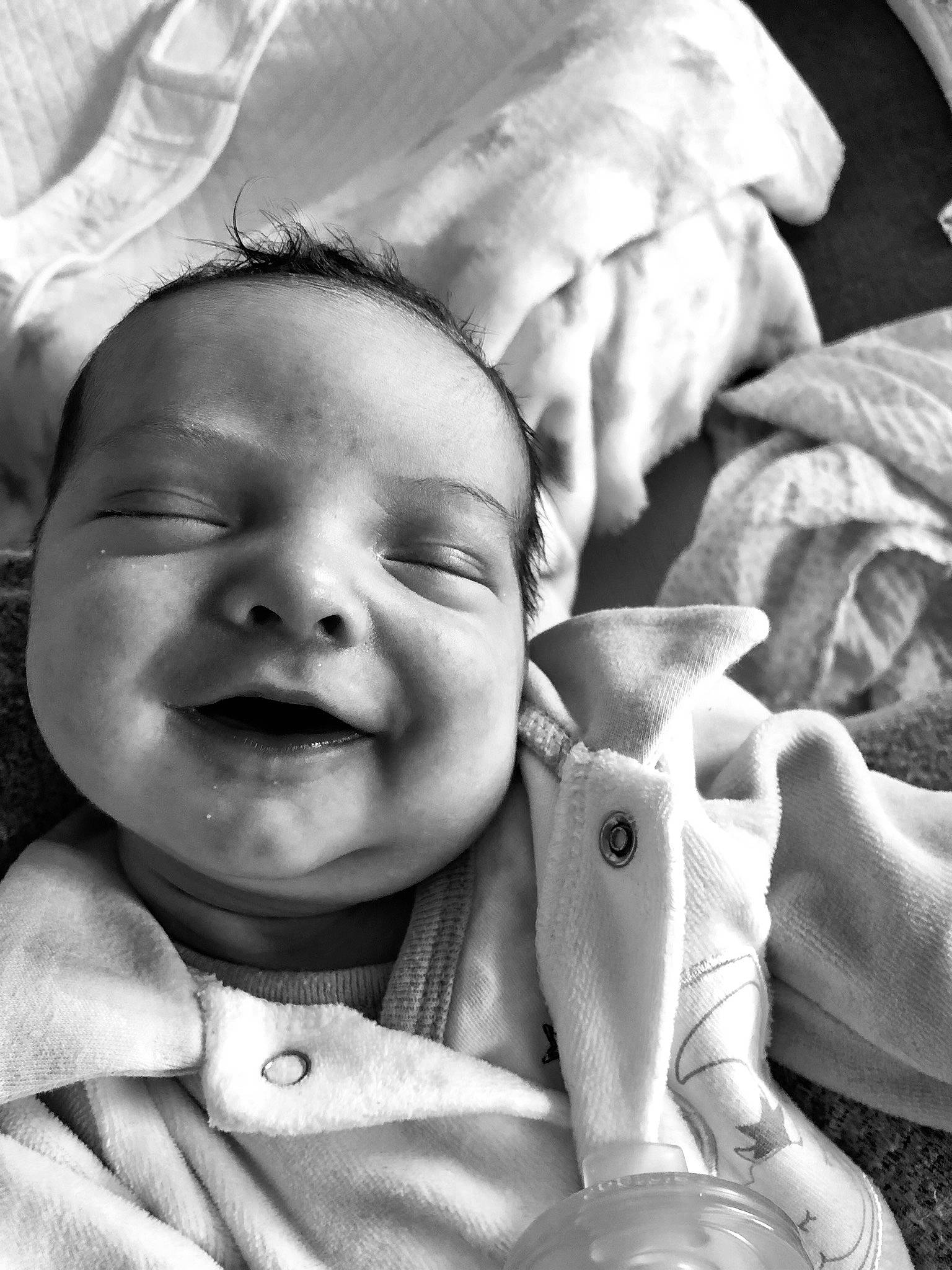 Sacha participe au concours pour gagner de l'argent avec cette photo : baby, bedtime, birth, black_and_white, child, eye, facial_expression, hand, happy, linens, monochrome, person, photograph, photography, skin, smile, style, toddler