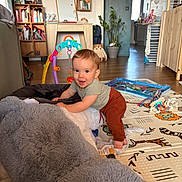 Hélio a rejoint le concours — aidez-le/la à gagner de superbes lots ! toddler, child, smile, indoor, plush_toy, playmat, toy, furniture, living_room, wooden_shelf, plant, floor, clothing, baby, happy, crawling, home, colorful, person, cute