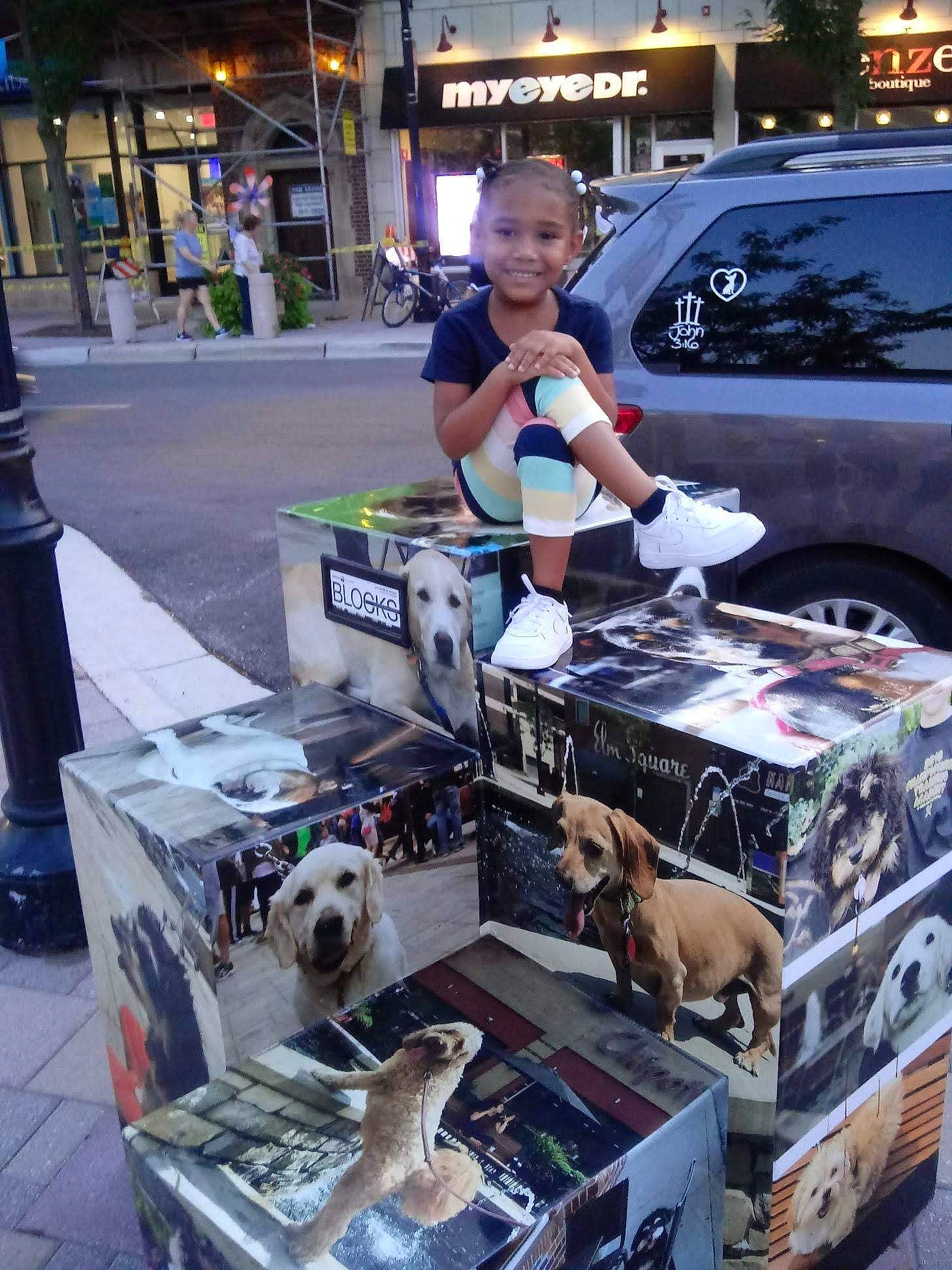 Amina is registered to the contest to win money with this photo: automotive_design, automotive_exterior, car, carnivore, city, companion_dog, dog, dog_breed, eyewear, flea_market, joy, luggage_and_bags, machine, motor_vehicle, person, public_space, sidewalk, technology, toddler, toy