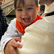 Evelyn is registered to the contest to win money with this photo: baby, child, smiling, happy, person, face, hand, clothing, sweater, outdoor, bridge, water, sunlight, adult, family, holding, portrait, cute, infant, nature