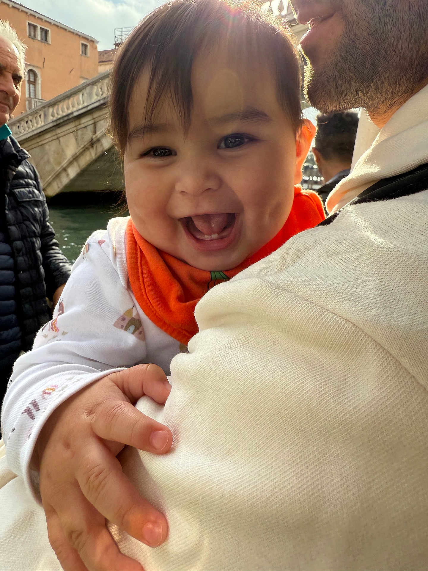 Evelyn is registered to the contest to win money with this photo: baby, child, smiling, happy, person, face, hand, clothing, sweater, outdoor, bridge, water, sunlight, adult, family, holding, portrait, cute, infant, nature