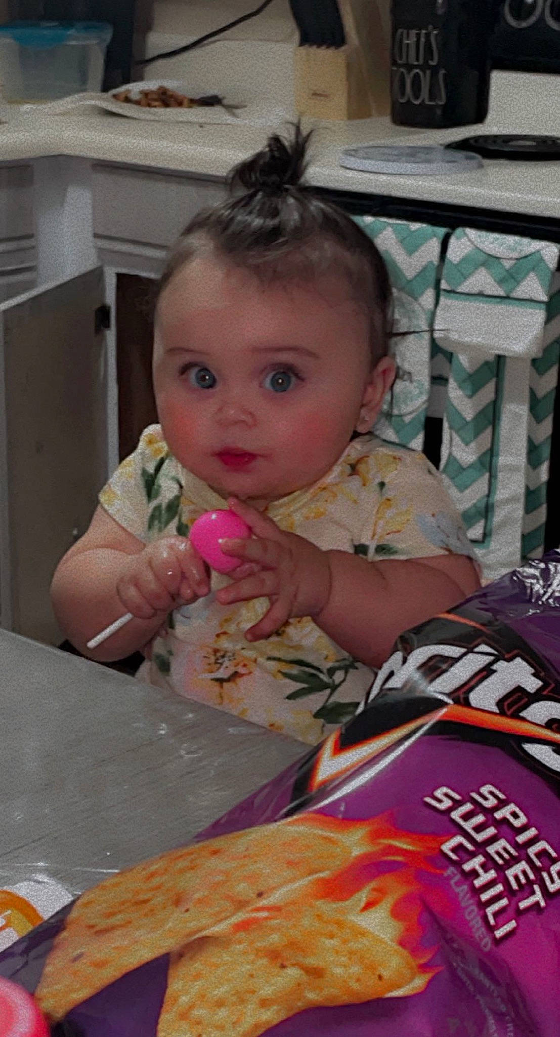 Khalisi is registered to the contest to win money with this photo: baby, chair, cheek, child, comfort_food, desk, eating, event, eyelash, face, food, fun, person, pink, sitting, skin, surprise, sweetness, table, tableware