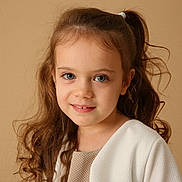 Maëline a rejoint le concours — aidez-le/la à gagner de superbes lots ! child, girl, portrait, smile, curly_hair, pony_tail, white_cardigan, beige_background, face, person, young, cute, innocence, soft_lighting, indoor, fashion, head_and_shoulders, happy, casual_clothing, studio_photo