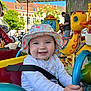 Lylia participe au concours pour gagner de l'argent avec cette photo : child, toddler, hat, smile, blue_eyes, carousel, ride, toy_duck, toy_monkey, outdoor, sunny, daylight, playful, colorful, seatbelt, clothing, person, amusement_ride, happy, fun
