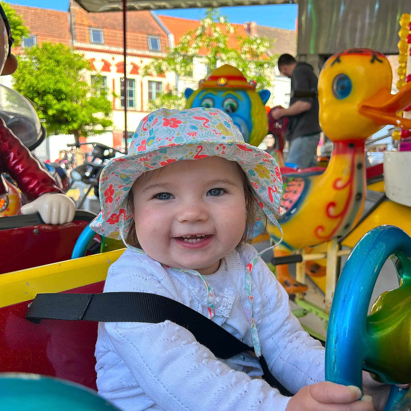Lylia participe au concours pour gagner de l'argent avec cette photo : amusement_ride, blue_eyes, carousel, child, clothing, colorful, daylight, fun, happy, hat, outdoor, person, playful, ride, seatbelt, smile, sunny, toddler, toy_duck, toy_monkey