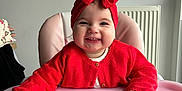 Lylia participe au concours pour gagner de l'argent avec cette photo : baby, baby_girl, cheerful, child, clothing, cute, furniture, happy, headwear, high_chair, indoor, infant, person, pink_high_chair, portrait, red_headband, red_sweater, sitting, smiling, toothy_grin
