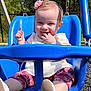 baby, child, swing, playground, blue_swing, smiling, headband, flower, outdoor, sunny, grass, trees, clothing, happy, infant, person, seat, footwear, nature, play