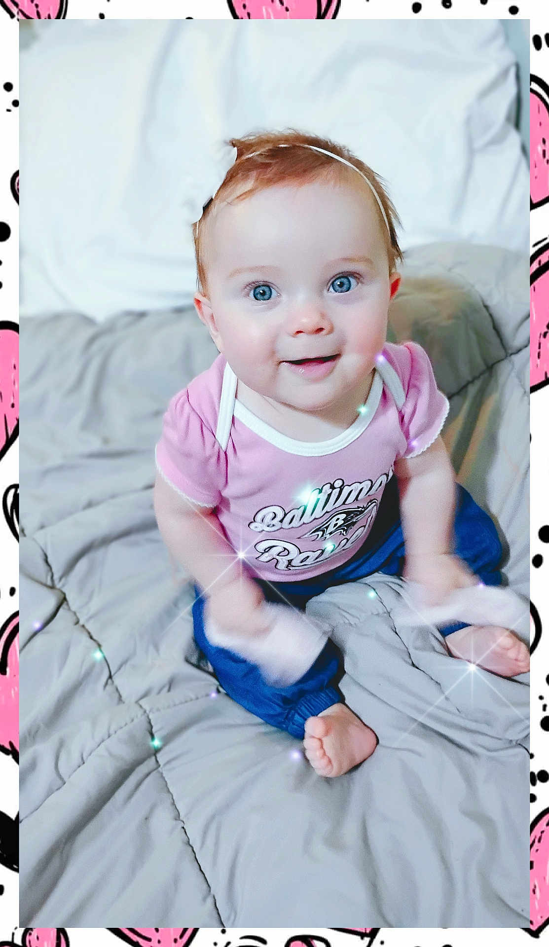 Kaeli Rose is registered to the contest to win money with this photo: baby, barefoot, bed, blanket, blue_eyes, blue_pants, child, clothing, cute, face, happy, headband, indoors, infant, person, pink_shirt, portrait, seated, smiling, sparkles