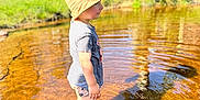 Xuann a rejoint le concours — aidez-le/la à gagner de superbes lots ! child, water, pond, hat, striped_shirt, shorts, sandals, reflection, ripples, sunlight, grass, car, clothes_drying_rack, tree, outdoor, summer, nature, daylight, backyard, person