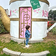 Xuann a rejoint le concours — aidez-le/la à gagner de superbes lots ! child, denim_jacket, denim_pants, white_shoes, grass, teacup_house, pink_door, golden_accents, outdoor, daylight, greenery, bottle, curly_hair, side_view, decorative, playful, garden, small_person, fantasy, whimsical