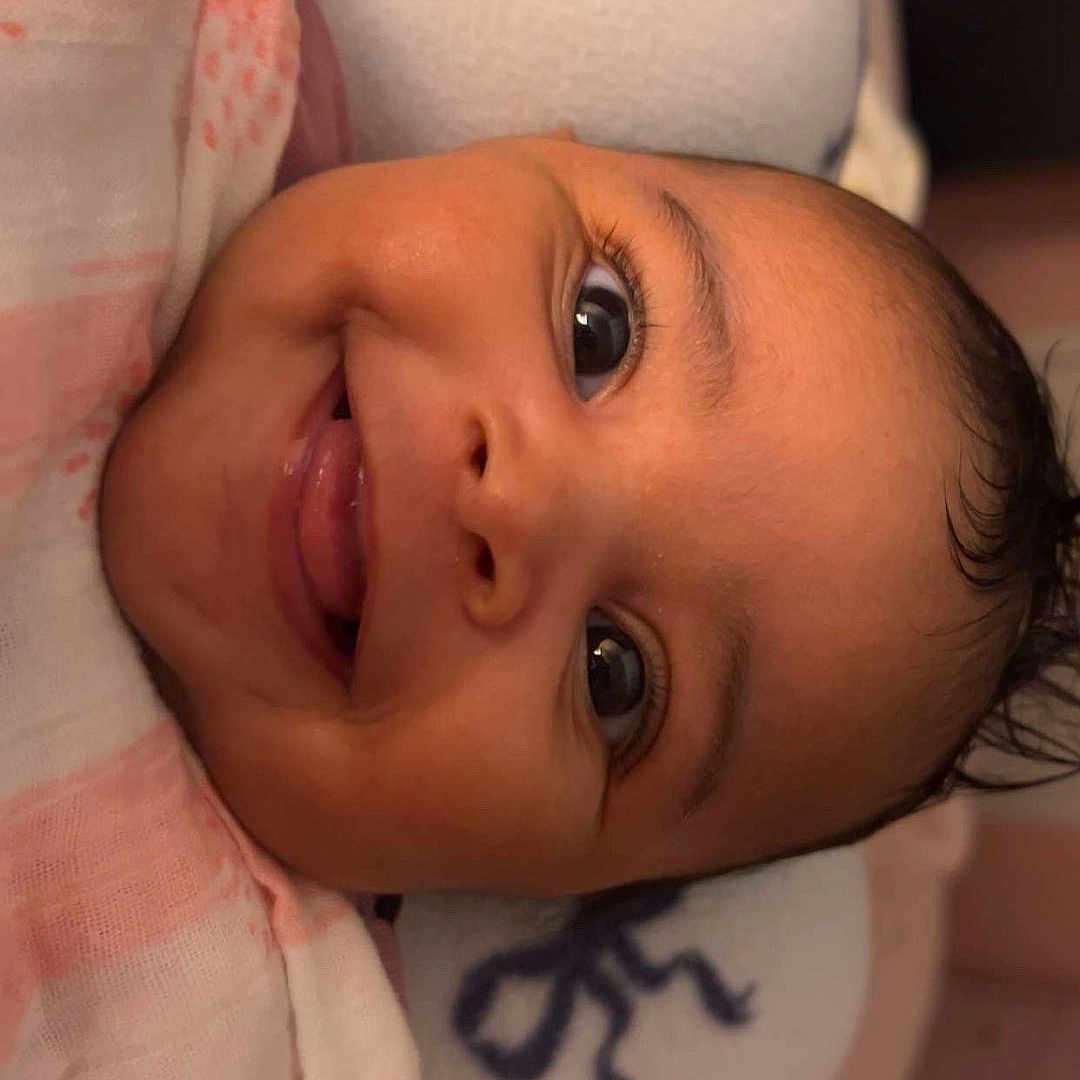 Alora joined the competition — help win amazing prizes! baby, blanket, child, closeup, cozy, cute, expression, eyes, face, happy, head, indoors, infant, lying_down, pillow, portrait, skin, smiling, soft, young