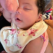 Jai'Lani is registered to the contest to win money with this photo: baby, sleeping, plush_toy, bib, floral_pattern, cuddling, peaceful, infant, cute, closeup, soft_toy, pink, fabric, resting, child, portrait, cozy, relaxed, person, indoor