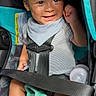baby, car_seat, smiling, toy, bottle, striped_clothing, bib, seatbelt, infant, sunlight, happy, child, sitting, hand_raised, face, cute, indoor, safety, comfort, playful