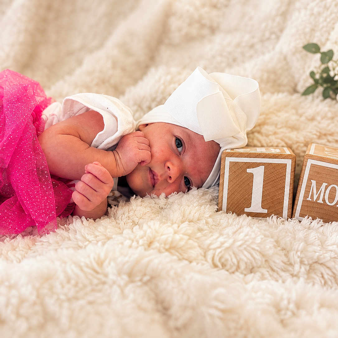 Storie joined the competition — help win amazing prizes! newborn, baby, infant, child, portrait, lying_down, sleeping, awake, smiling, pink_outfit, white_headband, large_bow, blanket, fluffy, wooden_blocks, one_month, milestone, baby_photography, indoor, plant