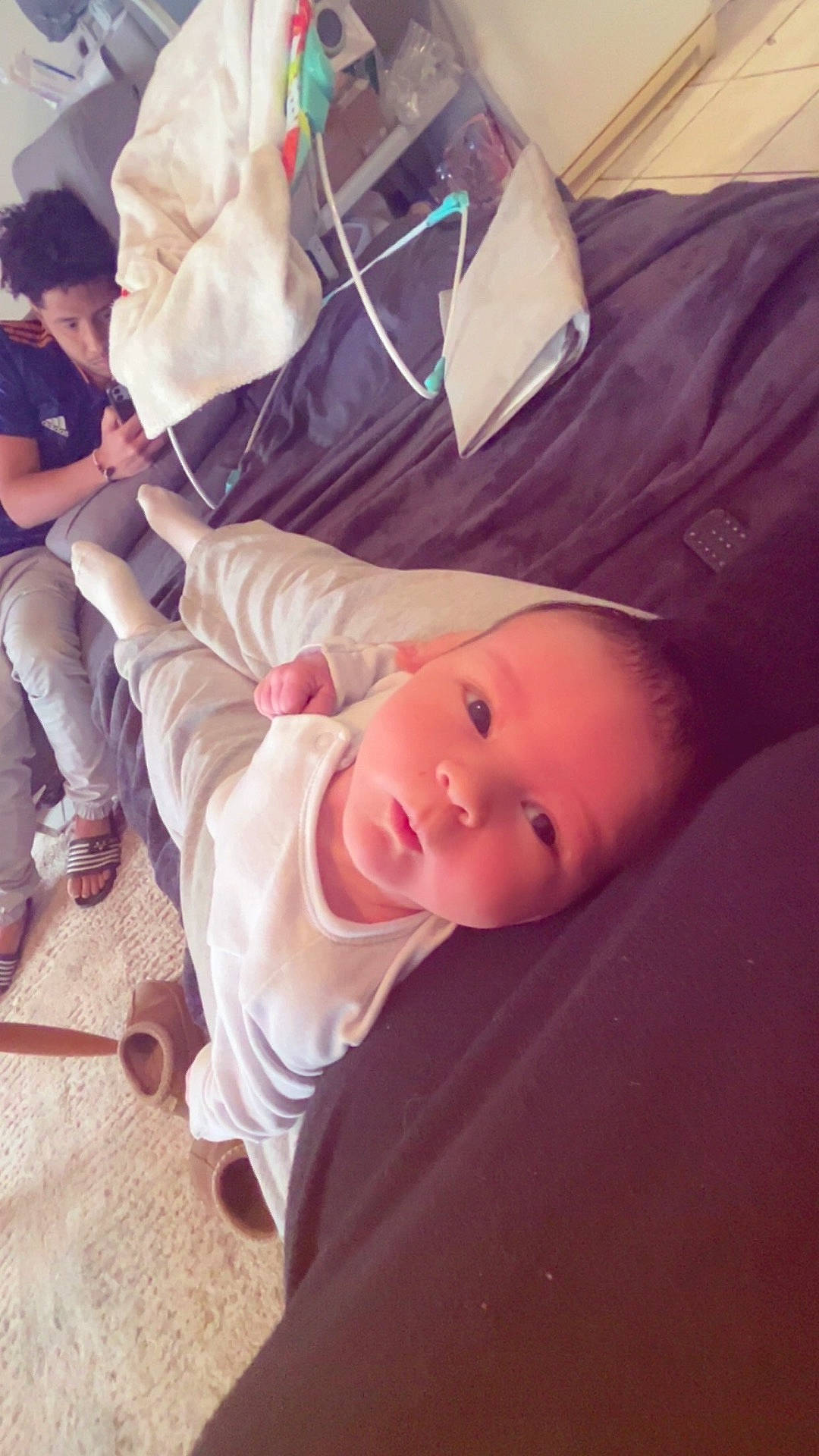 Lyam a rejoint le concours — aidez-le/la à gagner de superbes lots ! baby, blanket, carpet, casual, child, clothing, couch, curious, floor, furniture, home, indoor, legs, person, phone, portrait, relaxing, slippers, socks, young_person